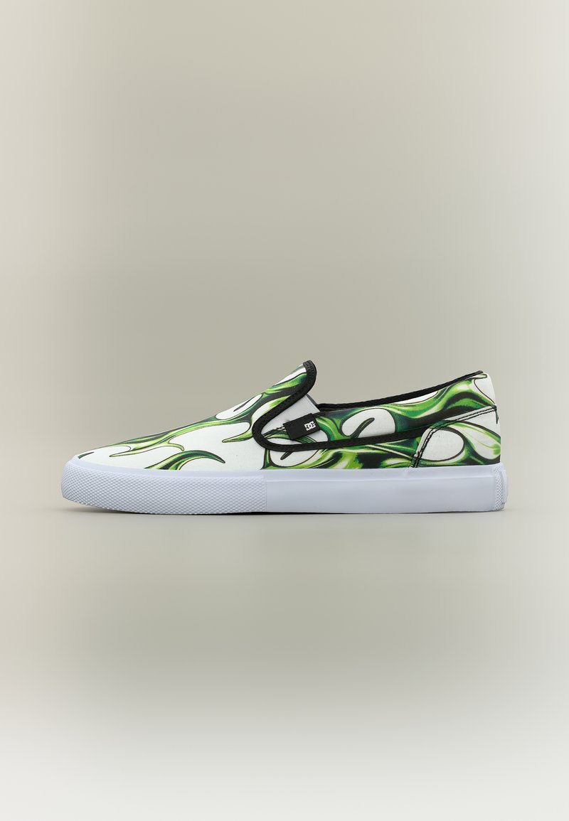 Λευκό sneaker χωρίς κορδόνια με πράσινο και μαύρο μοτίβο φλόγας, μαύρη περιφέρεια και χοντρή λευκή σόλα, εμφανίζεται από το πλάι σε ουδέτερο φόντο.