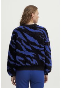 Črno-modra puhasta pulover s tigrovim črtastim vzorcem, okroglo izrezom in balonskimi rokavi, z rebrastim robom in manšetami.
