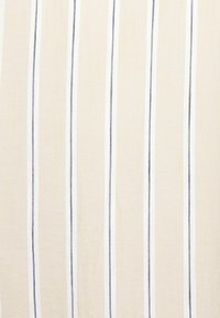 Tissu beige clair avec des rayures verticales blanches et bleu foncé, légèrement texturé avec une finition douce. Idéal pour diverses applications textiles.