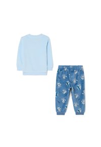 Haut long bleu clair à col rond associé à un pantalon de pyjama bleu avec des motifs d'animaux ludiques et une taille élastique.
