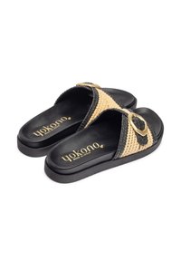 Schwarze Sandalen mit geflochtenen Stroh-Akzenten, ausgestattet mit einer goldenen Schnalle und einer strukturierten schwarzen Sohle. Markenlogo auf der Innensohle sichtbar.
