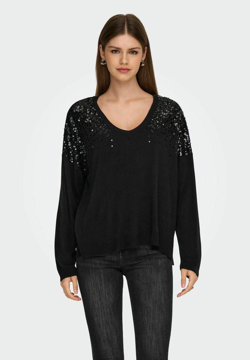 Pull noir avec un décolleté en V, agrémenté de sequins sur les épaules. Manches longues et coupe décontractée, fabriqué dans un tissu doux.