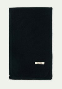 Svart filt av mjuk tyg med en slät textur. Har en liten, krämfärgad etikett med varumärket "GOBI" i ett hörn.