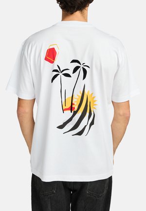 White cotton t-shirt featuring a colorful graphic design with palm trees, a sun, and abstract shapes in red, yellow, and black on the back.