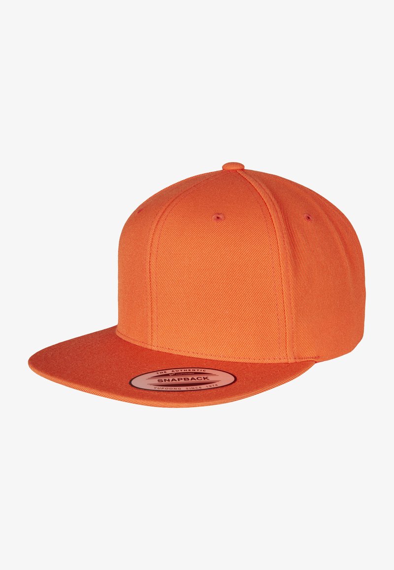 Narancssárga snapback sapka textúrált anyagból, ívelt karimával és kör alakú logóval az elején. Hatpaneles korona kialakítás.