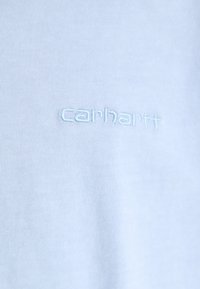 Világoskék pamut póló, az elején finoman, dombornyomott "Carhartt" logóval, megegyező cérnával. Puha és sima tapintású.