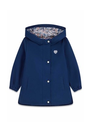 Giacca impermeabile blu navy con foderato a motivi floreali, bottoni a pressione e un logo a forma di cuore sul petto. Polsini elasticizzati e cappuccio.