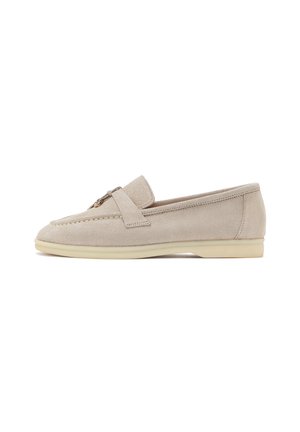 Beige ruskind loafer med lav beige sål, syning detaljer og metal accent på den øverste rem vist i sideprofil.