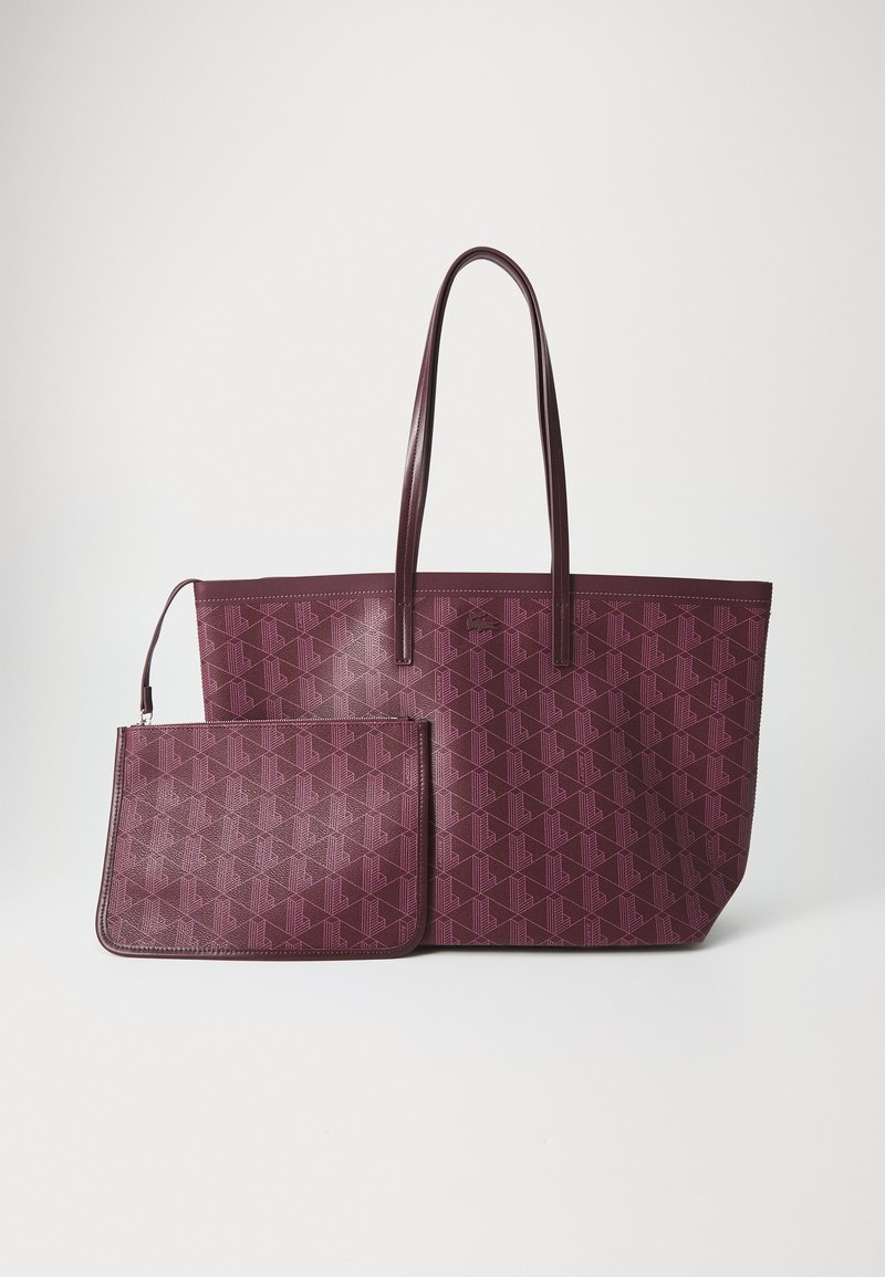 Bordeaux spalvos rankinė su geometriniu raštu, turinti dvi ilgas rankenas ir nuimamą mažesnę kišenę su užtrauktuku. Sklandi tekstūra.