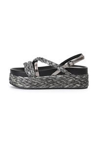 Sandalo con plateau nero e cinturini intrecciati, caratterizzato da dettagli metallici e una suola texturizzata intrecciata, progettato in tonalità di grigio.