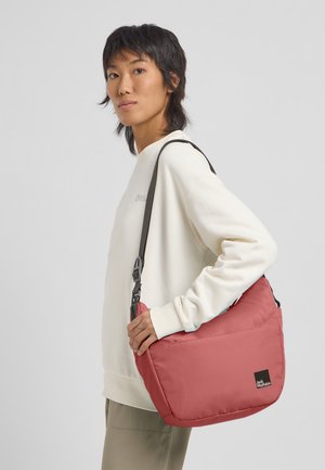 Rote Schultertasche aus strapazierfähigem Gewebe mit gepolstertem Design, ausgestattet mit einem schwarzen Logopatch und einem verstellbaren Tragegurt für zusätzlichen Komfort.