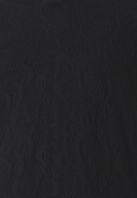 Mustaa kangasta, jossa on tekstuurinen kuvio pyörteillä, luoden hienovaraisen visuaalisen efektin. Materiaali vaikuttaa pehmeältä ja neulotulta.