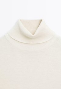 Roomkleurige coltrui gemaakt van zachte stof, met een dubbele kraag, geribbelde randen en een soepel oppervlak.