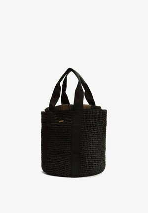 Sac panier tote noir tissé avec deux larges anses en tissu et un petit logo rectangulaire sur le côté sur fond blanc.