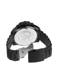 Montre en acier inoxydable noir avec un boîtier rond, des boutons de chronographe et un bracelet à maillons. Motif de lion gravé au dos. Résistante à l'eau jusqu'à 10 bars.