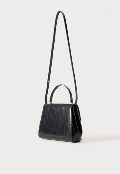 Sac à main en cuir noir avec une poignée supérieure et une longue bandoulière ajustable, présentant un motif texturé vertical discret.