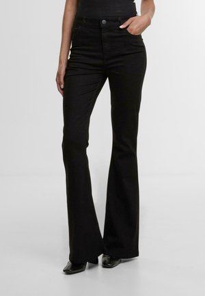 Schwarze, ausgestellte Jeans mit hoher Taille, ausgestattet mit vorderen Taschen, einem Knopfverschluss und einem glatten, strukturierten Stoff. Eng an den Oberschenkeln.