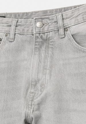 Close-up van lichtgrijze denim jeans met de tailleband, riemlussen, metalen knoop en details van de stiksels van de voorzak.