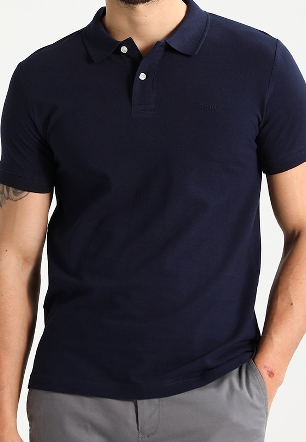Polo bleu marine en coton, à manches courtes, avec un col, deux boutons et un logo discret sur la poitrine. Texture lisse.
