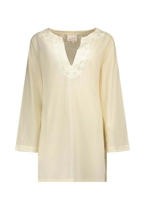 Tunica crema a maniche lunghe con scollo a V e ricamo floreale intorno allo scollo e ai polsini delle maniche.