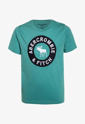 Børne-T-shirt med korte ærmer i blågrøn med rund halsudskæring, der har en sort cirkulær logo-patch med hvid elg og teksten "Abercrombie & Fitch".
