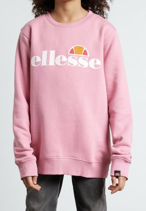 Różowa bluza z miękkiego materiału, z białym logo "ellesse" i małym pomarańczowym akcentem nad napisem. Długie rękawy i ściągacze przy mankietach.