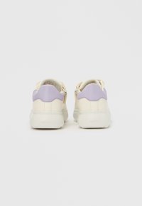 Női sportcipők krémszínű bőr felsőrésszel és levendulakék részletekkel, hullámos mintával a saroknál, valamint fehér gumitalppal.