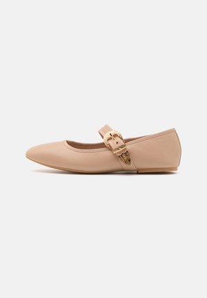 Beige balerina cipő lekerekített orral és állítható pánttal, díszes arany csattal és sima szintetikus felső résszel.