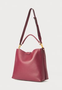 Borsa a mano in pelle bordeaux con una finitura testurizzata, parte superiore arrotondata, una maniglia per il trasporto e una tracolla regolabile con dettagli in metallo dorato.
