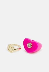 Duas alianças: uma faixa dourada brilhante com um rosto sorridente e uma aliança em forma de coração rosa brilhante com um detalhe em strass.