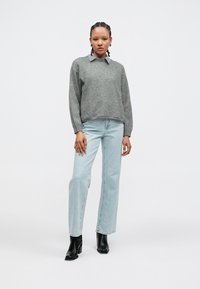 Gray sweater with a collared neckline over a light blue shirt, paired with light blue straight-leg jeans and black ankle boots.