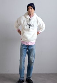 Hoodie branco e fofinho com o logótipo "POLO", colarinho interior rosa; jeans azul claro; sapatos pretos; gorrinho azul. Design simples, ajuste casual.