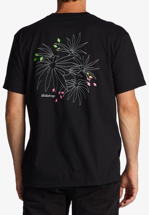 T-shirt en coton noir présentant un motif floral dessiné en lignes blanches au dos, agrémenté de formes géométriques vertes, roses et jaunes.