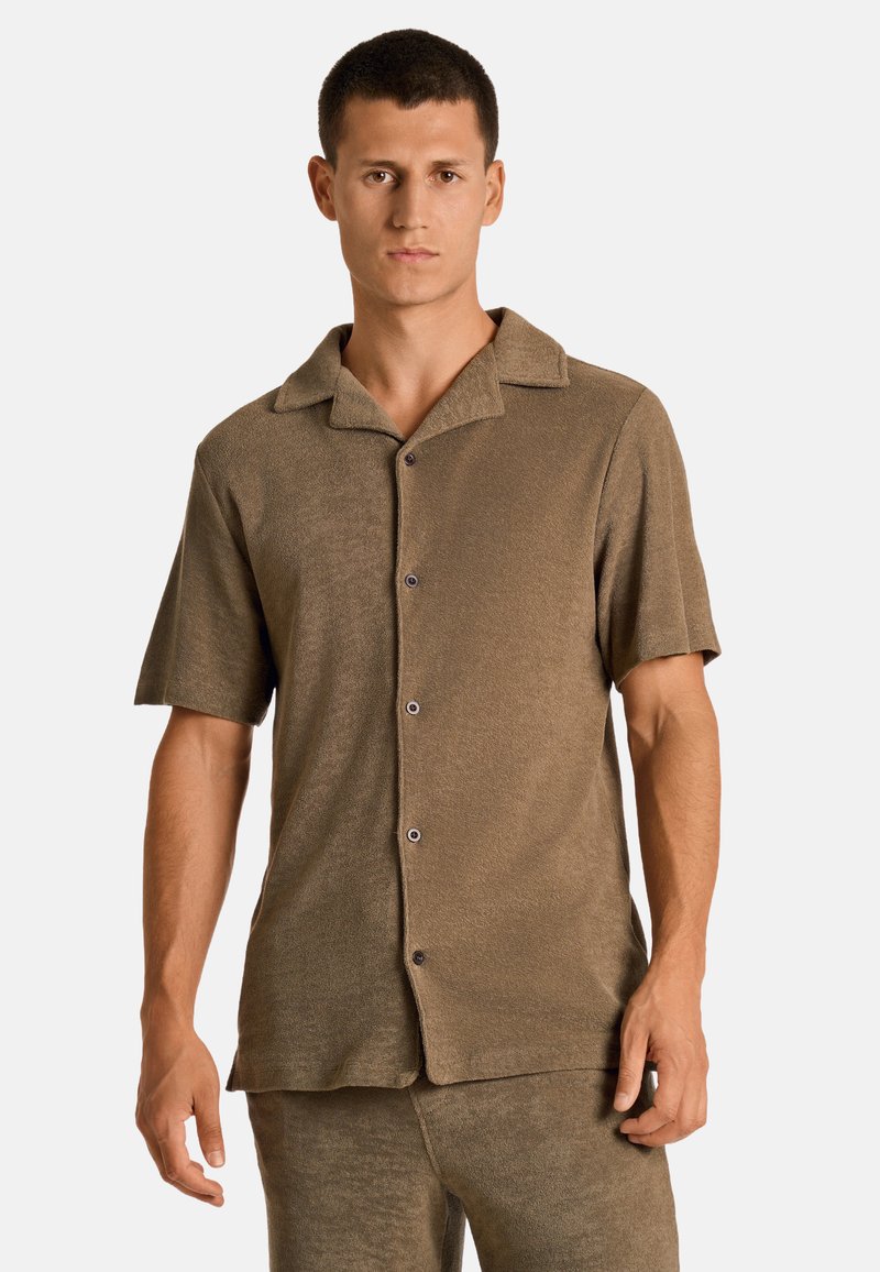 Korte mouw shirt in een textuur bruin stof, voorzien van een kraag en vijf knopen aan de voorkant. Glad afwerking met een ontspannen pasvorm en subtiele glans.