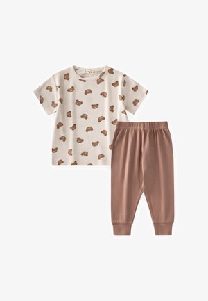 Detský outfit s béžovým tričkom s krátkym rukávom zdobeným hnedými tvárami medveďov a hnedými rebrovanými elastickými nohavicami s manžetami pri členkoch.