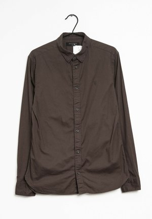 Chemise marron à manches longues avec une patte de boutonnage sur le devant, un col classique et un petit logo brodé sur la poitrine. Tissu en coton lisse.