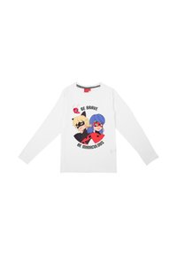 T-shirt bianco a maniche lunghe con una grafica colorata di due personaggi in maschera, con il testo "SII CORAGIOSO SII MIRACOLOSO" e una coccinella.