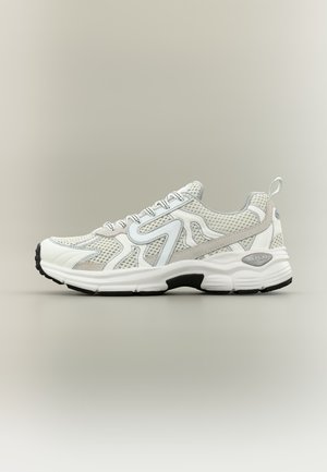 Αθλητικό παπούτσι από λευκό και γκρι δίχτυ με χοντρή σόλα, θηλιά στο πίσω μέρος και μαύρες λεπτομέρειες στη σόλα, εμφανιζόμενο από το πλάι σε φωτεινό φόντο.