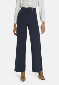 Marineblauwe wijde broek met hoge taille, voorzien van twee decoratieve knopen, zijzakken en een gladde, textuurachtige stof.