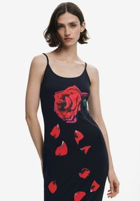 Fekete ruha nagyméretű piros rózsával és hulló szirmokkal. Vékony pántokkal  és testhezálló fazonnal rendelkezik. Sima textúra.