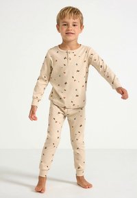 Beżowe bawełniane prążkowane piżamy z guzikowym dekoltem, ozdobione kolorowym kwiatowym wzorem. Zestaw obejmuje długie rękawy i dopasowane spodnie.