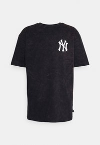 Černé oversized tričko vyrobené z jemného materiálu, s bílým logem New York Yankees na levé části hrudi. Hladká textura, rovný střih, krátké rukávy.