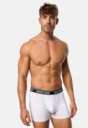 Weißer Boxer-Brief aus weichem Stoff, mit einem schwarzen elastischen Bund, der das "INDICODE"-Logo trägt. Figurbetonte Passform, schlichtes Design, glatte Textur.