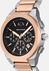 Armani Exchange käekell musta kellapinnaga, roosakuldne ja hõbedane metallriba, kolm aladialku, kuupäevanäidik ning helendavad käed ja markerid.