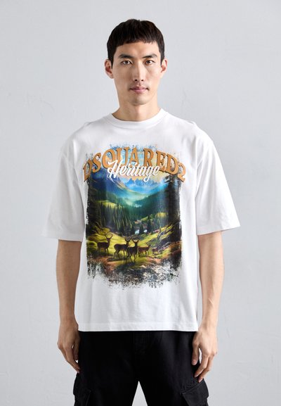 White cotton t-shirt featuring a nature scene with deer and mountains, detailed with graphic print and brown lettering "DSQUARED2 Heritage."