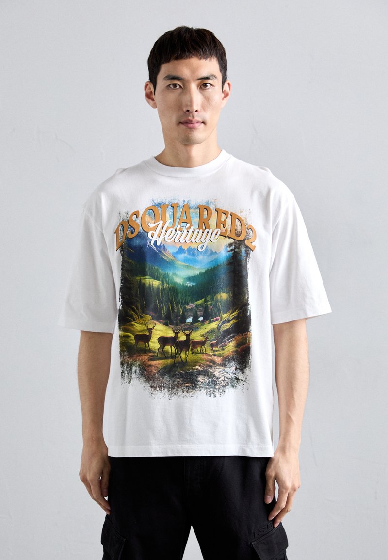Hvid bomulds t-shirt med et naturscene, der viser hjorte og bjerge, detaljeret med grafisk tryk og brun skrift "DSQUARED2 Heritage."