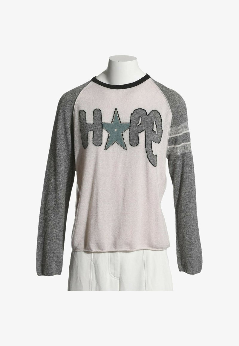 Pull à manches longues avec corps rose clair, manches grises à rayures, et le mot "HOPE" en grandes lettres avec une étoile remplaçant le O.
