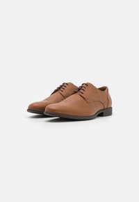 Brown leather dress shoes with smooth texture, rounded toe, and lace-up design. Black rubber sole with minimal tread pattern.
