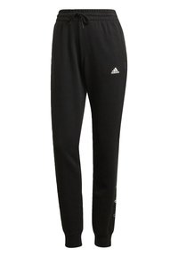 Svarta joggingsbyxor i mjukt tyg, med resårmidja och dragsko, sidofickor och en vit logotyp på vänster lår.