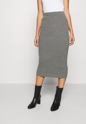 Grijs geribbeld gebreid midi-skirt met een hoge taille, gecombineerd met een aansluitend wit topje en zwarte hoge enkelboots. Gladde textuur, eenvoudig ontwerp.